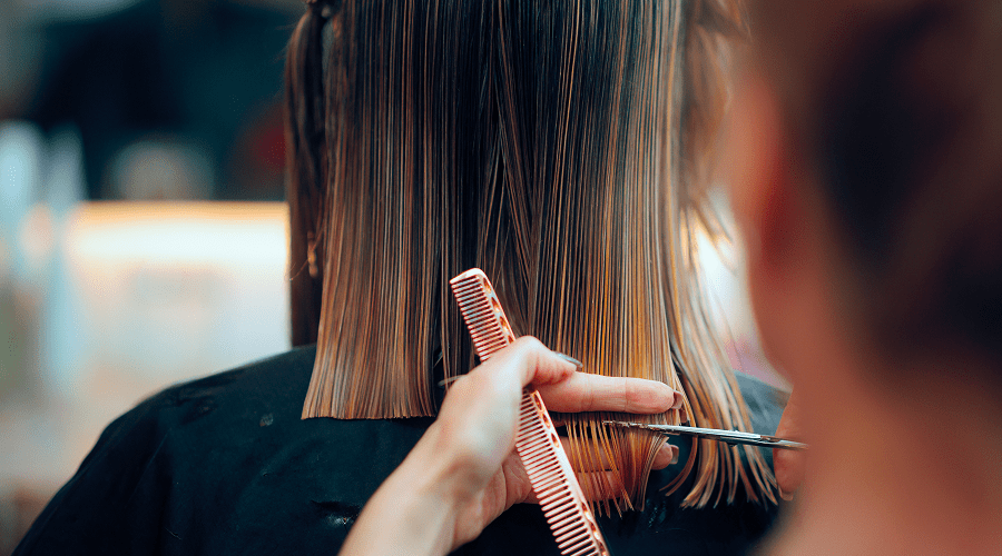 Haircut in progress with scissors and comb