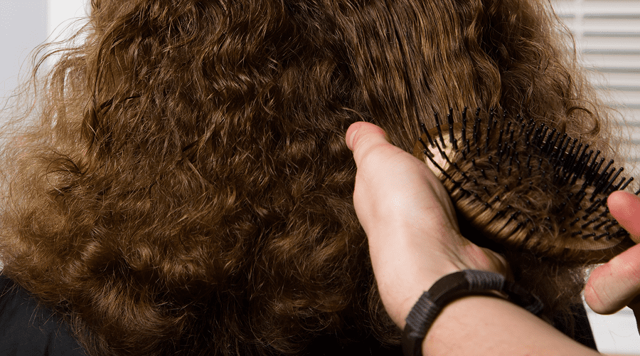 Hands combing thick curly hair